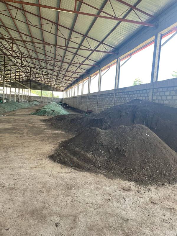 Compost piles curing in a large roofed co-composting hall